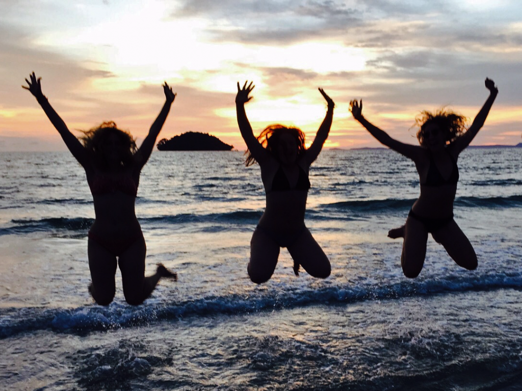 women leaping in the air on a beach