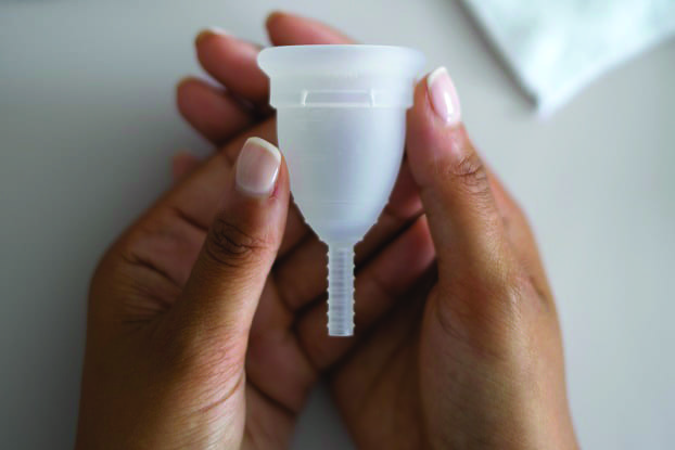 Hands holding a Mooncup menstrual cup