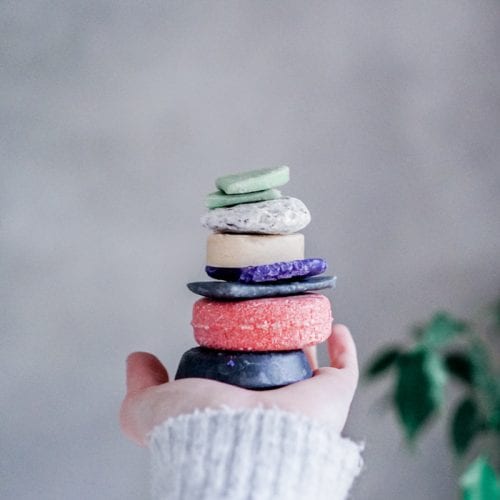 Stack of shampoo and conditioner bars stacked on hand