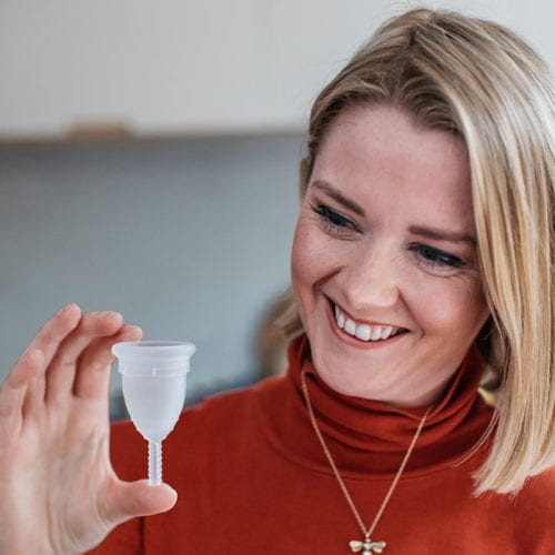 Emilie holding a Mooncup menstrual cup between her fingers